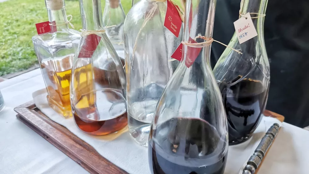 Osem steklenic različnega žganja. / Foto: Miha First