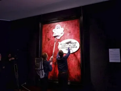 This photo released by Animal Rising shows activists pasting a picture of a character called Wallace, from the "Wallace and Gromit" comedy series, over a portrait of Britain's King Charles III at the Philip Mould Gallery in London, Tuesday June 11, 2024. Animal rights activists pasted a cartoon image over a portrait of King Charles III on Tuesday at a London art gallery, the latest in a series of incidents at U.K. museums as campaigners use vandalism to publicize their causes. (Animal Rising via AP)