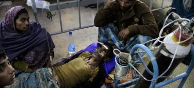 A patient is surrounded by relatives as he takes oxygen and saline while being treated in a hospital after drinking toxic alcohol in Diamond Harbour, near Kolkata, India, Thursday, Dec. 15, 2011. A tainted batch of bootleg liquor has killed scores and sent dozens more to the hospital in villages outside Kolkata, officials said. (AP Photo/Bikas Das)