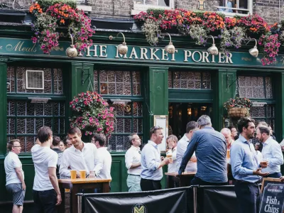 London, UK - July 23, 2019: People standing and drinking outside The Market Porter English pub in Borough Market, one of the largest and oldest food markets in London. Selective focus.
