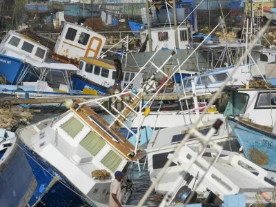 A fisherman looks at fishing vessels damaged by Hurricane Beryl at the Bridgetown Fisheries in Barbados, Monday, July 1, 2024. (AP Photo/Ricardo Mazalan)