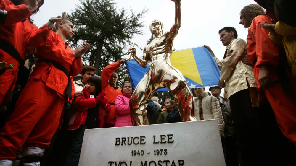 Bosnian Kung Fu practitioners applaud a newly unveiled bronze statue of Bruce Lee, a Chinese-American martial arts master in a typical fighting pose during a ceremony in Mostar November 26, 2005. A new symbol of unity was erected on Saturday in the ethnically divided Bosnian city of Mostar - a statue of Kung Fu legend Bruce Lee, worshipped by Muslims, Serbs and Croats. A group of enthusiasts in Mostar, the scene of fighting between Muslims and Croats in 1993-1994, agreed they needed a symbol of justice, mastery and honesty - virtues upheld by the late Chinese-American actor.  REUTERS/Damir Sagolj