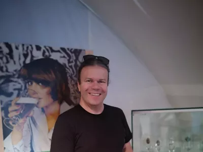 Tomaž Majcen s kriglo piva ob enem od razstavljenih panojev v Muzeju Laško. / Foto: Mojca Marot