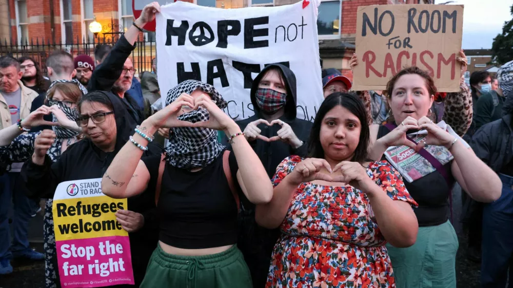 People take part in a protest outside a mosque in Liverpool, Britain, August 2, 2024.  REUTERS/Belinda Jiao