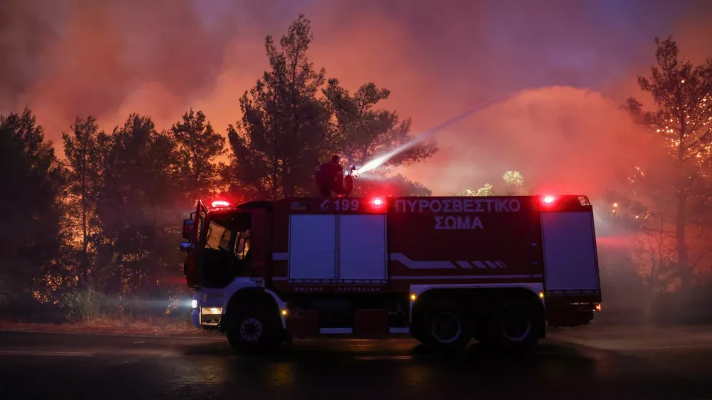 A firefighter tries to extinguish a wildfire burning in Dionysos, Greece, August 12, 2024. REUTERS/Alexandros Avramidis