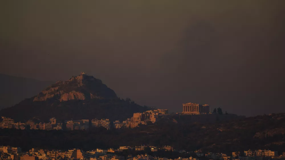 A general view of the of Athens with the Acropolis hill as fire burns the northern part of the city on Monday, Aug. 12, 2024, while hundreds of firefighters tackle a major wildfire raging out of control on fringes of Greek capital. (AP Photo/Petros Giannakouris)