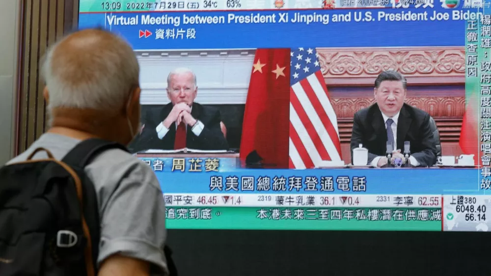 A screen displays images of Chinese President Xi Jinping and U.S. President Joe Biden, while broadcasting news about their recent call at a shopping mall in Hong Kong, China, July 29, 2022. REUTERS/Tyrone Siu