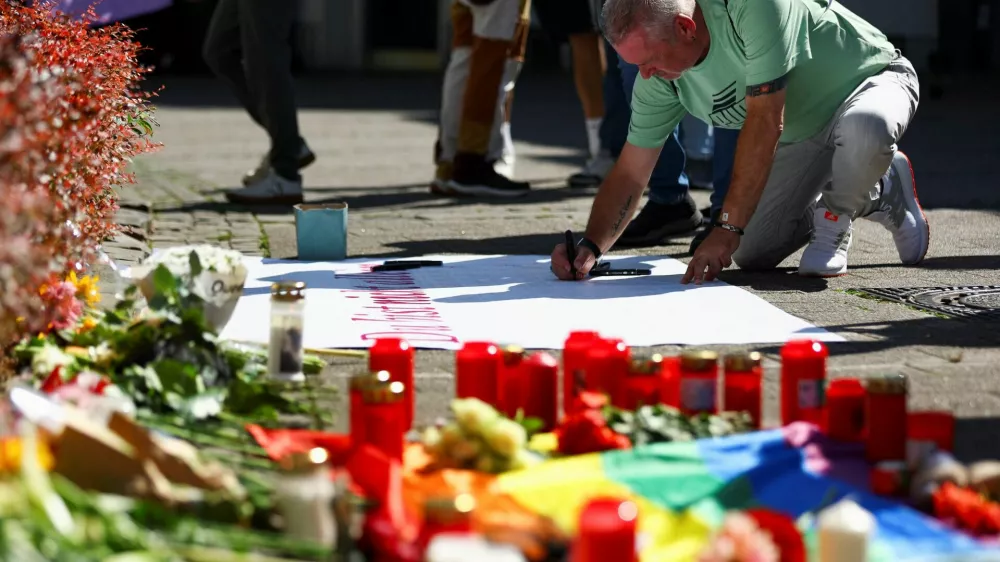 A man writes a message on a placard following an incident in which several individuals were killed after a man randomly stabbed passers-by with a knife at a city festival, in Solingen, Germany, August 24, 2024. REUTERS/Thilo Schmuelgen