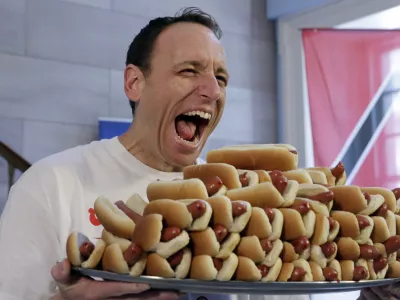 Current men's champion Joey Chestnut, of San Jose, Calif., holds a tray of hot dogs during the weigh-in for the 2017 Nathan's Hot Dog Eating Contest, in Brooklyn Borough Hall, in New York, Monday, July 3, 2017. Chestnut weighed-in at 221.5 pounds. (AP Photo/Richard Drew)