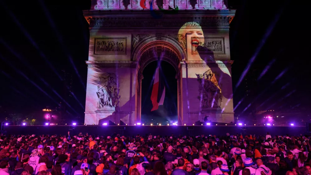 Attendees watch a recorded Lady Gaga performance projected on the Arc de Triomphe at the end of the parade of French athletes who competed in the Paris 2024 Olympic and Paralympic Games in Paris, France, September 14, 2024. ED JONES/Pool via REUTERS
