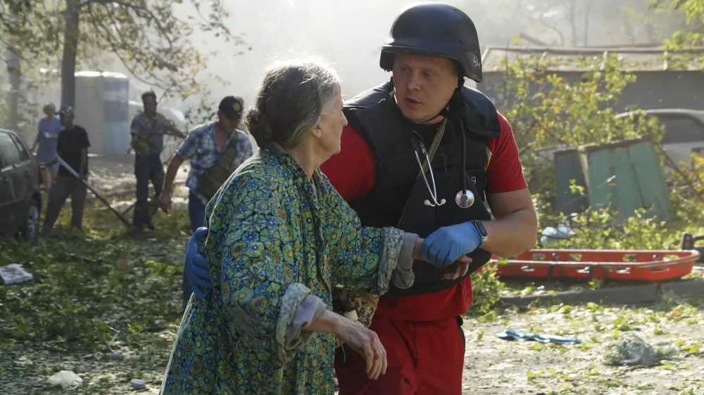 An elderly woman is assisted after a Russian aerial bomb struck a multi-story residential building in Kharkiv, Ukraine, Sunday Sept. 15, 2024. (AP Photo/Andrii Marienko)