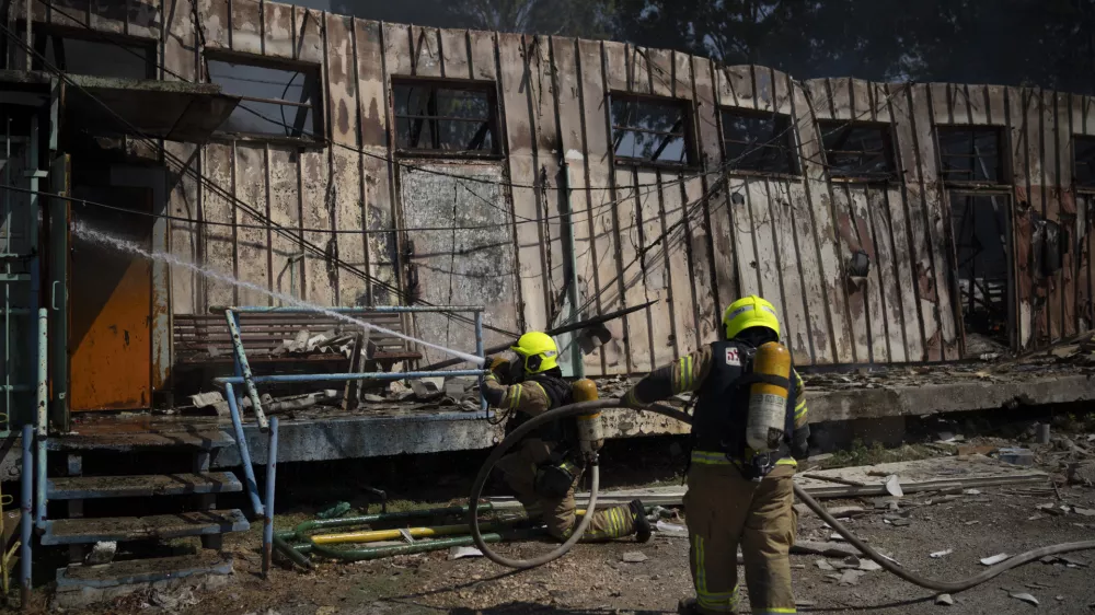 Firefighters work to extinguish a fire after a rocket, fired from Lebanon, hit a local municipality storage in Kiryat Shmona, northern Israel, Tuesday, Sept. 24, 2024. (AP Photo/Leo Correa)
