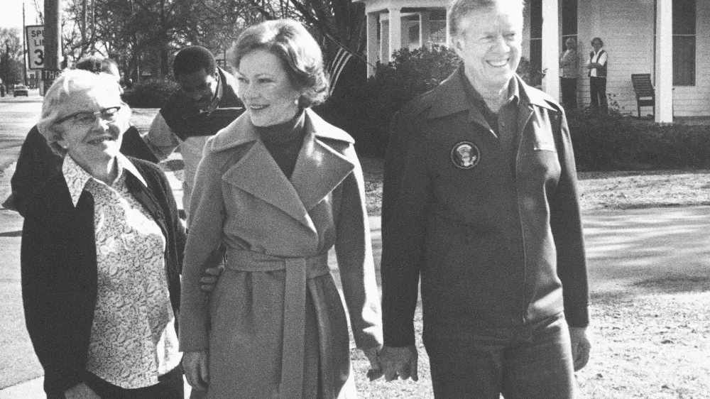 FILE - Former President Jimmy Carter, right, wife Rosalynn, center, and mother-in-law Allie Smith walk through Plains, Ga., Jan. 23, 1981, back home from their office. Well-wishes and fond remembrances for the former president continued to roll in Sunday, Feb. 19, 2023, a day after he entered hospice care at his home in Georgia. (AP Photo/Wayne Perkins, File)