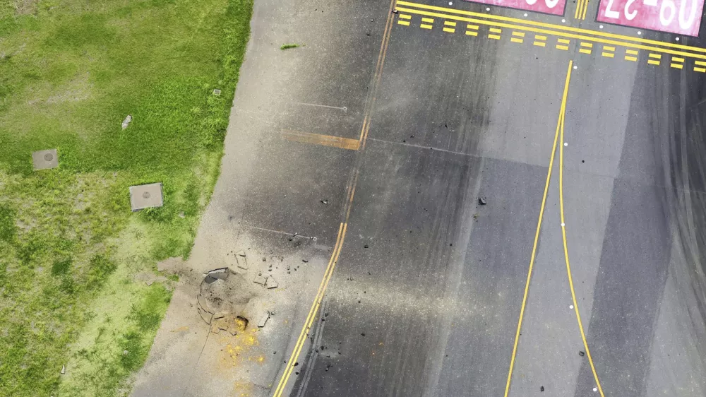 This photo taken from a Kyodo News helicopter shows part of a damaged taxiway, center, at Miyazaki Airport in southwestern Japan, Wednesday, Oct. 2, 2024, after an explosion was reported. (Kyodo News via AP)