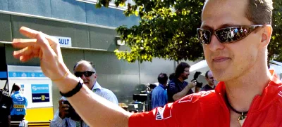 Formula One Ferrari driver Michael Schumacher of Germany waves as he arrives at the track in Melbourne, Australia, Thursday, March 30, 2006. Melbourne will host the seasons 3rd Grand Prix Sunday, April 2. (AP Photo/Steve Holland)