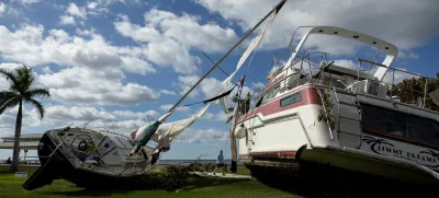 A man walks past boats resting in a public park after they were washed ashore when Hurricane Milton passed through the area, in Punta Gorda, Florida, U.S., October 10, 2024. REUTERS/Ricardo Arduengo