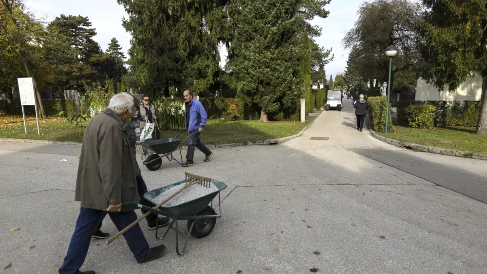 V ponedeljek so ljudje poskrbeli še za zadnje lepotne popravke na grobovih. Foto: Luka Cjuha