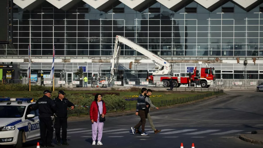 People walk by as a rescue team inspects the area where a part of a roof of a railway station collapsed in Novi Sad, Serbia November 2, 2024. REUTERS/Marko Djurica