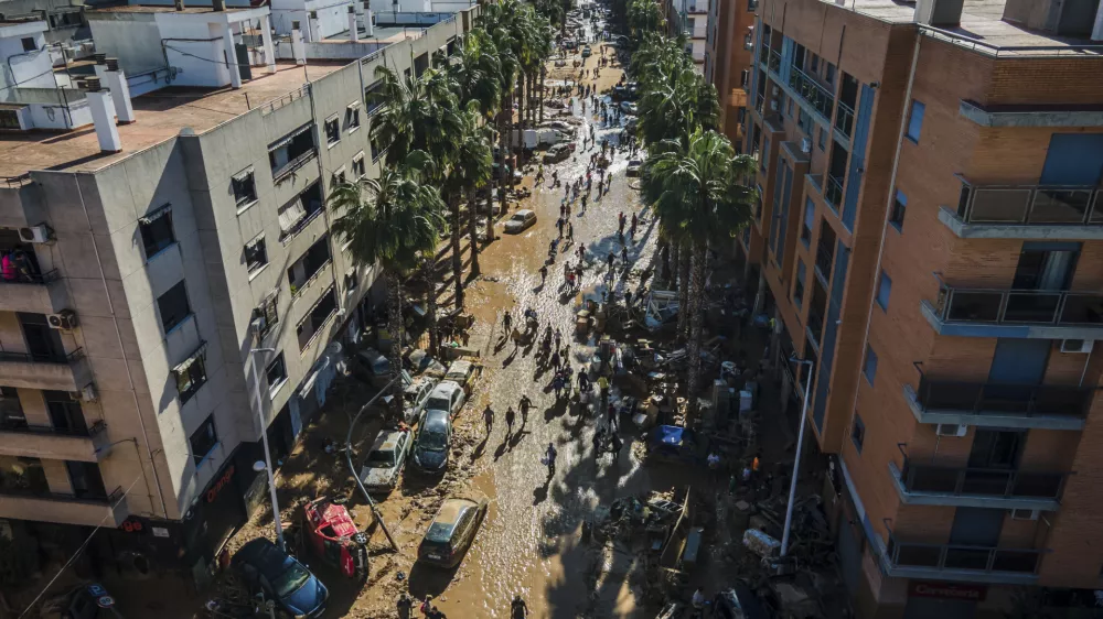 Volunteers and residents clean the mud four days after flash floods swept away everything in their path in Paiporta, outskirts of Valencia, Spain, Saturday, Nov. 2, 2024.(AP Photo/Angel Garcia)