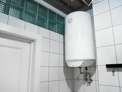 2H4M5HW Modern gas tanked boiler in bathroom. Household budget water heater hanging on the wall in boiler room. Common electric storage tank water heater