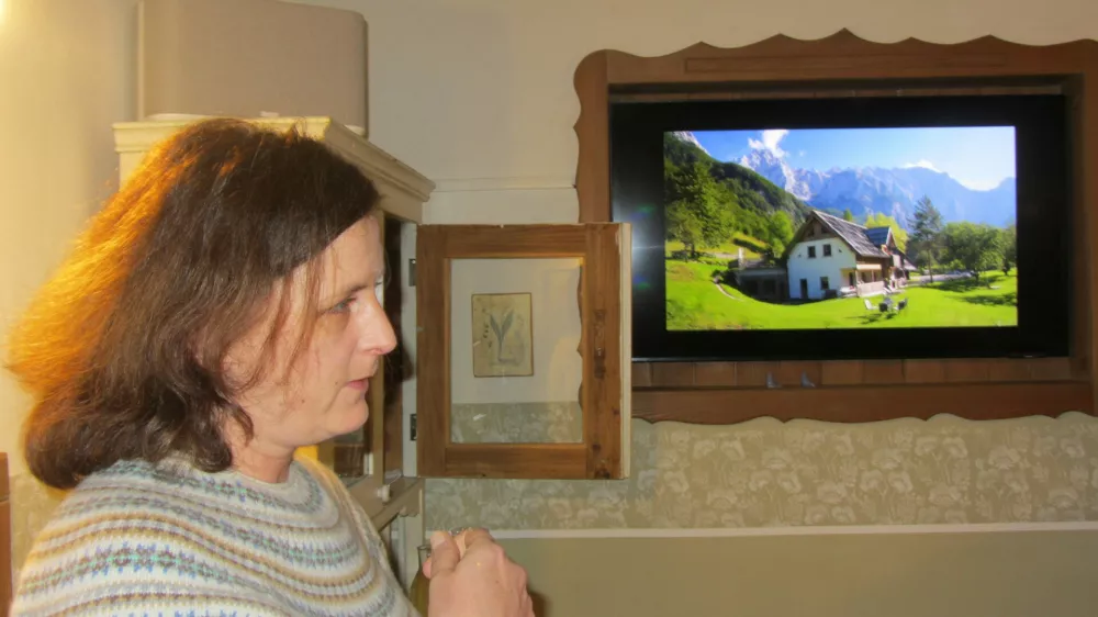 Urška Lenar zaradi obilnega dežja, predstavlja življenje kmetije, pod varno streho in predstavlja domačijo s pomočjo diaprojekcijie na steni zajtrkovalnice.