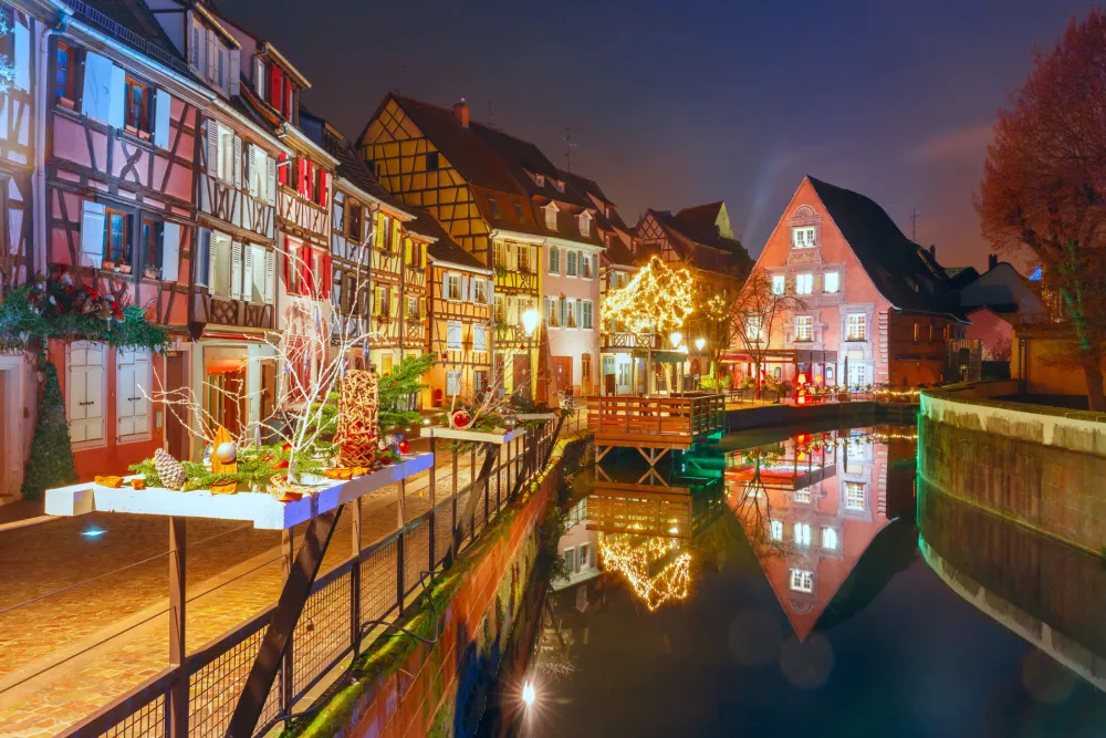 Traditional Alsatian half-timbered houses in Petite Venise or little Venice, old town of Colmar, decorated and illuminated at snowy christmas night, Alsace, France / Foto: Kavalenkavavolha