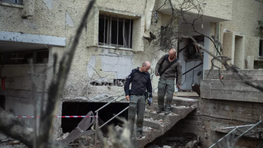 24 November 2024, Israel, Rinatya: Israeli Security personnel inspect the site, where a building was hit by a Hezbollah rocket strike from Lebanon. Photo: Ilia Yefimovich/dpa