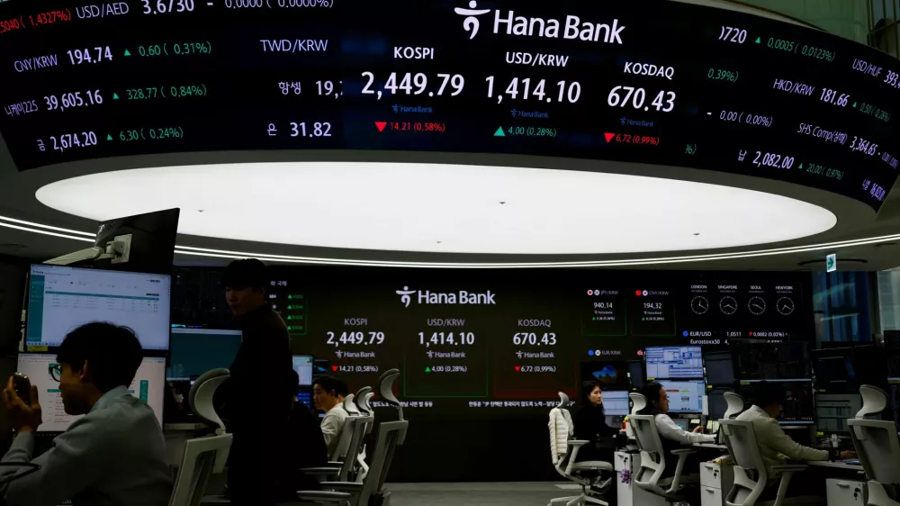 Currency dealers work in front of an electronic board showing the Korean Composite Stock Price Index (KOSPI) in the dealing room of a bank in Seoul, South Korea, December 5, 2024. REUTERS/Kim Soo-hyeon