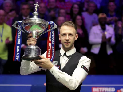 ﻿Britain's Judd Trump lifts the trophy after winning the 2019 Snooker World Championship after beating Scotland's John Higgins, at The Crucible, in Sheffield, England, Monday May 6, 2019. (Richard Sellers/PA via AP)