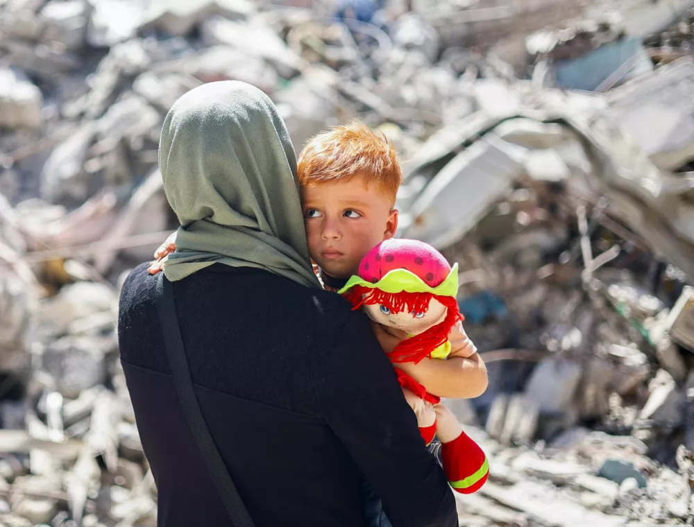 Palestinian woman Inas Abu Maamar, who was photographed at Nasser hospital morgue on October 17 cradling the body of her five-year-old niece Saly, killed in an Israeli strike, sits with her nephew Ahmed, Saly's brother, at the site where Saly was killed, in Khan Younis in the southern Gaza Strip September 11, 2024. REUTERS/Mohammed Salem