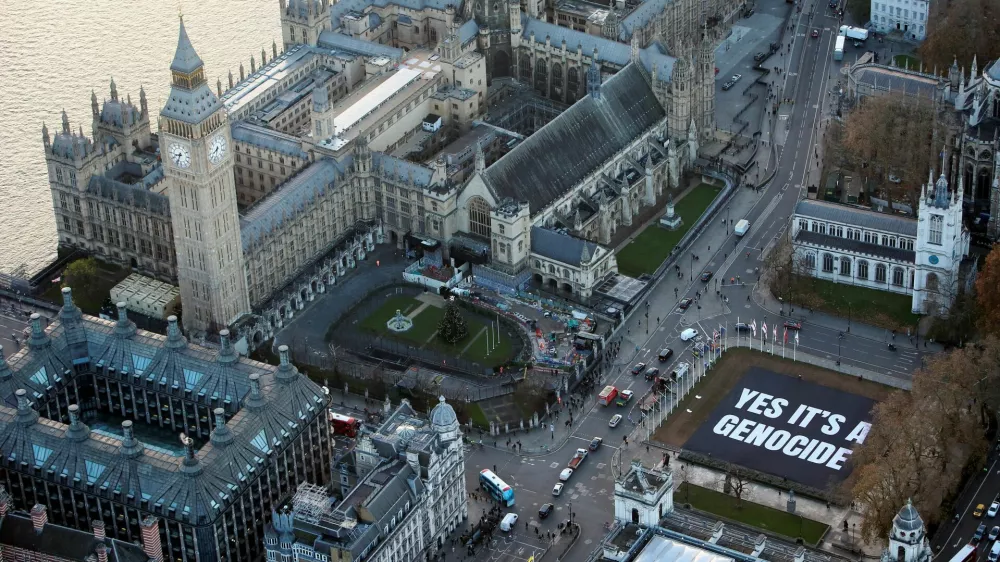 Cars drive past a banner put up by the protest group Led by Donkeys, quoting Israeli Holocaust professor Amos Goldberg's statement with regards to the Israel-Hamas conflict, in Parliament Square, London, Britain, December 4, 2024. Led by Donkeys/Handout via REUTERS THIS IMAGE HAS BEEN SUPPLIED BY A THIRD PARTY. MANDATORY CREDIT