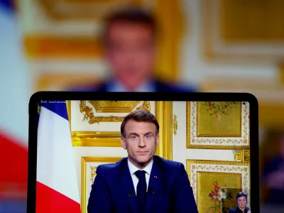 French President Emmanuel Macron appears on screen as he makes a television address to the nation after Prime Minister Michel Barnier's government was toppled in a no confidence vote in parliament, in Paris, France, December 5, 2024. REUTERS/Christian Hartmann