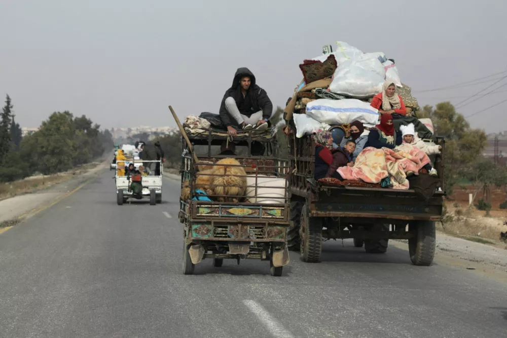 People ride on vehicle with belongings in Hama, after rebels led by HTS have sought to capitalize on their swift takeover of Aleppo in the north and Hama in west-central Syria by pressing onwards to Homs, in Hama, Syria December 6, 2024. REUTERS//Mahmoud Hasano   TPX IMAGES OF THE DAY