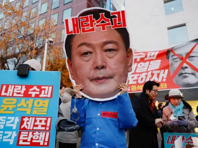 A protestor wears a face mask of South Korean President Yoon Suk Yeol in a rally calling for his impeachment, who declared martial law, which was reversed hours later, near the National Assembly in Seoul, South Korea, December 8, 2024. REUTERS/Kim Soo-hyeon