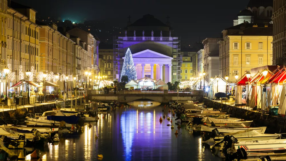 Trieste, Friuli Venezia Giulia, Italy - December 10, 2011: Italian city of Trieste on the Adriatic sea coast. Canal Grande over Ponte Rosso to the Sant'Antonio Nuovo Church in Christmas time night photograph.