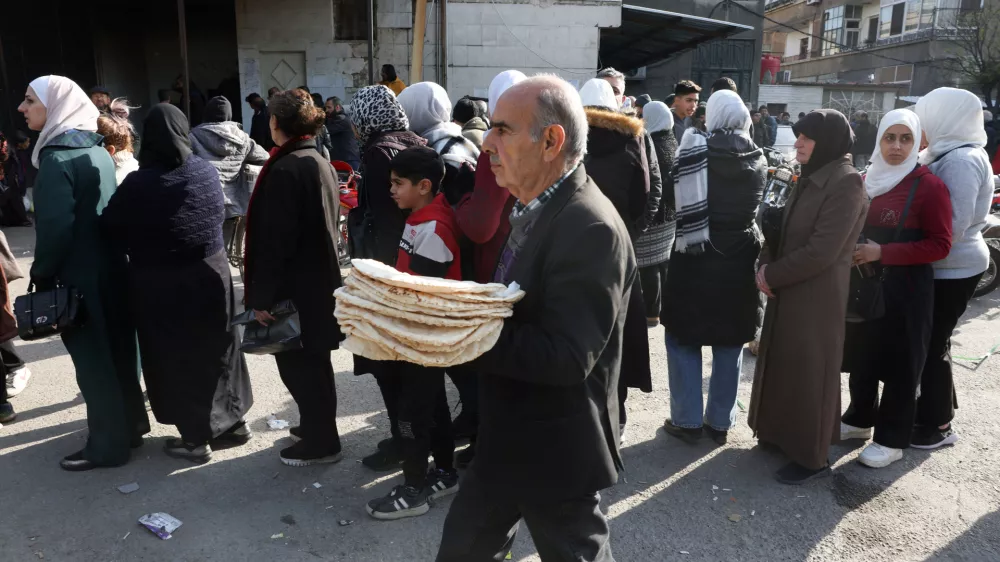 People queue to buy bread in Damascus, after rebels seized the capital and ousted Syria's Bashar al-Assad in Damascus, Syria December 9, 2024. REUTERS/Mohamed Azakir