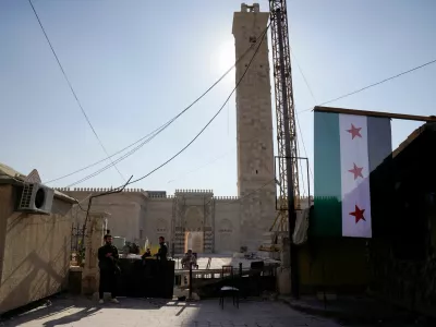 Rebel fighters with weapons keep watch at a barricade outside the Umayyad Mosque, after Syrian rebels announced that they have ousted Bashar al-Assad, in Aleppo, Syria, December 9, 2024. REUTERS/Karam al-Masri