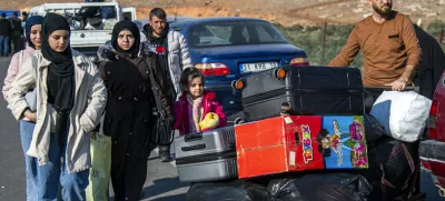 Syrian families arrive to cross into Syria from Turkey at the Cilvegozu border gate, near the town of Antakya, southern Turkey, Monday, Dec. 9, 2024. (AP Photo/Metin Yoksu)