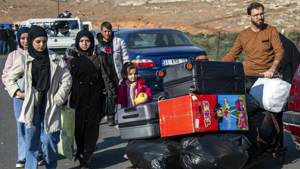 Syrian families arrive to cross into Syria from Turkey at the Cilvegozu border gate, near the town of Antakya, southern Turkey, Monday, Dec. 9, 2024. (AP Photo/Metin Yoksu)