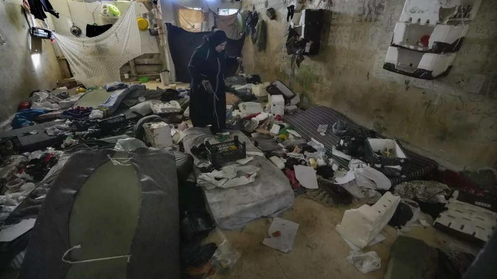 A woman looks at a room of the infamous Saydnaya military prison, just north of Damascus, Syria, Monday, Dec. 9, 2024. Crowds are gathering to enter the prison, known as the "human slaughterhouse," after thousands of inmates were released following the rebels' overthrow of Bashar al-Assad's regime on Sunday. (AP Photo/Hussein Malla)