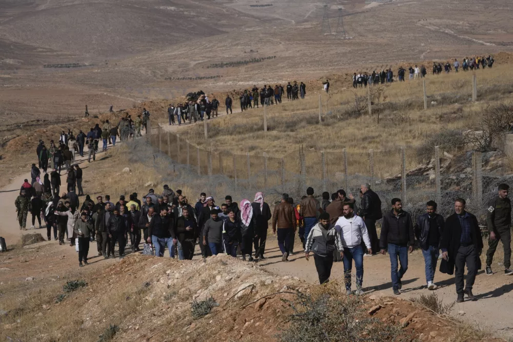 A line of people heads toward the infamous Saydnaya military prison, just north of Damascus, Syria, Monday, Dec. 9, 2024. Crowds are gathering to enter the prison, known as the "human slaughterhouse," after thousands of inmates were released following the rebels' overthrow of Bashar al-Assad's regime on Sunday. (AP Photo/Hussein Malla)