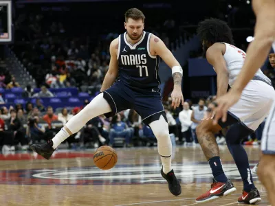 Dec 5, 2024; Washington, District of Columbia, USA; Dallas Mavericks guard Luka Doncic (77) dribbles the ball as Washington Wizards forward Marvin Bagley III (35) defends in the first quarter at Capital One Arena. Mandatory Credit: Geoff Burke-Imagn Images