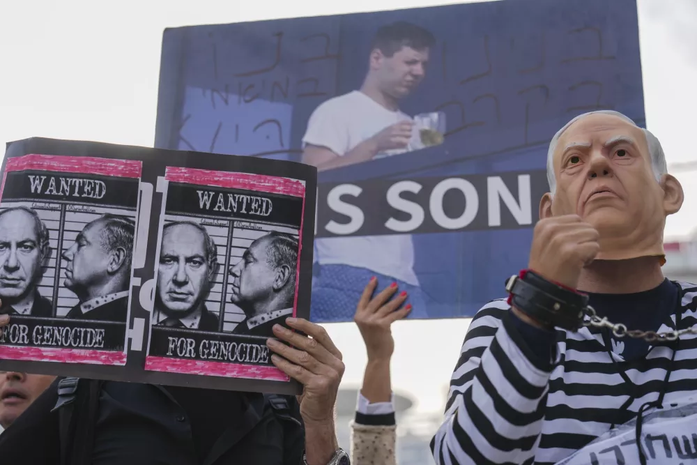 Demonstrators protest against Prime Minster Benjamin Netanyahu outside the court in Tel Aviv Tuesday Dec. 10, 2024. Netanyahu is set to take the stand on Tuesday in his long-running trial for alleged corruption.(AP Photo/Ariel Schalit)