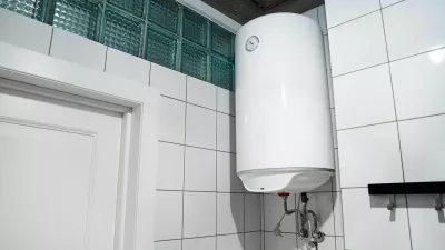 2H4M5HW Modern gas tanked boiler in bathroom. Household budget water heater hanging on the wall in boiler room. Common electric storage tank water heater