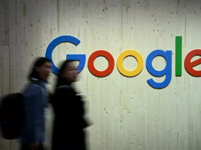 FILE PHOTO: People walk next to a Google logo during a trade fair in Hannover Messe, in Hanover, Germany, April 22, 2024. REUTERS/Annegret Hilse/File Photo