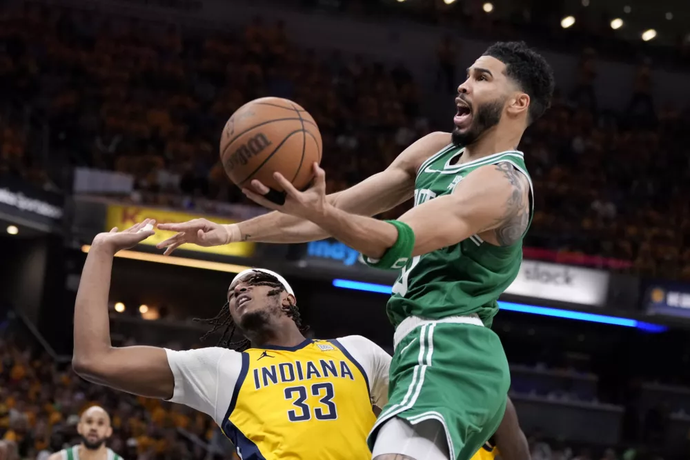 Boston Celtics forward Jayson Tatum (0) drives to the basket over Indiana Pacers center Myles Turner (33) during the first half of Game 4 of the NBA Eastern Conference basketball finals, Monday, May 27, 2024, in Indianapolis. (AP Photo/Michael Conroy)