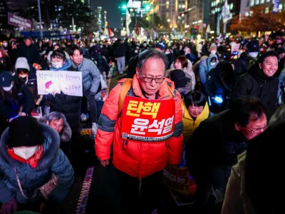 A protester carries a sign that reads "Impeach Yoon Suk Yeol" during a rally calling for the impeachment of South Korean President Yoon Suk Yeol, who declared martial law, which was reversed hours later, in front of the National Assembly in Seoul, South Korea, December 10, 2024. REUTERS/Kim Hong-Ji