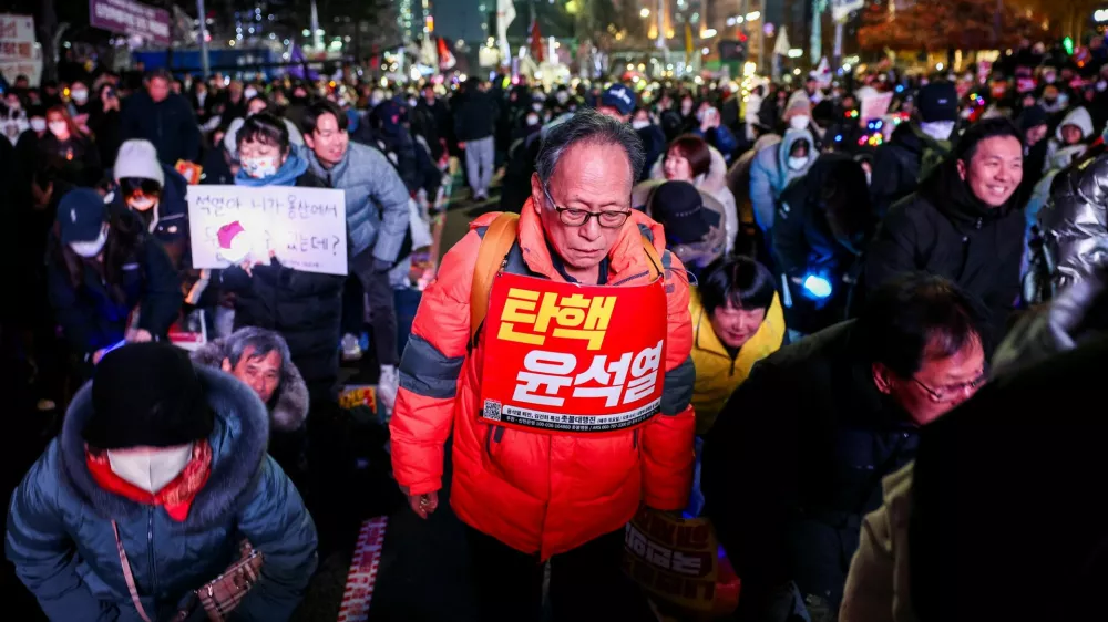 A protester carries a sign that reads "Impeach Yoon Suk Yeol" during a rally calling for the impeachment of South Korean President Yoon Suk Yeol, who declared martial law, which was reversed hours later, in front of the National Assembly in Seoul, South Korea, December 10, 2024. REUTERS/Kim Hong-Ji