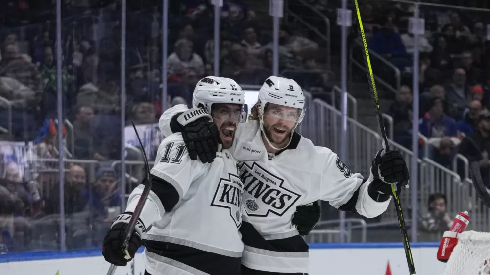 Los Angeles Kings' Adrian Kempe (9) celebrates with Anze Kopitar (11) after scoring a goal during the first period of an NHL hockey game against the New York Islanders Tuesday, Dec. 10, 2024, in Elmont, N.Y. (AP Photo/Frank Franklin II)