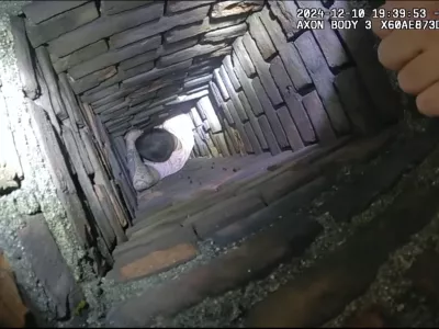 This image provided by City of Fall River Police Department shows police encounter of a man attempting to evade arrest by hiding inside a chimney on Tuesday, Dec. 10, 2024 in Fall River, Mass. (City of Fall River Police Department via AP) 